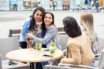 Smiling friends using digital tablet