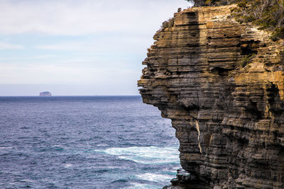 Rock formations in sea against sky