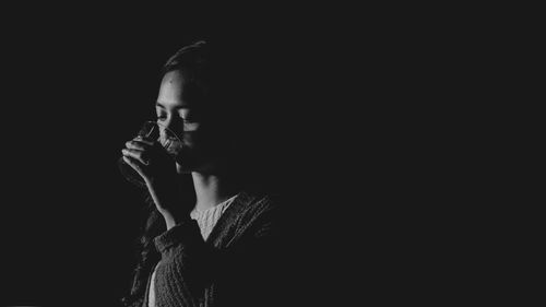 Portrait of woman against black background