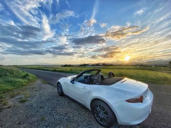 Car on road against sky during sunset