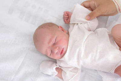 High angle view of cute boy sleeping on bed