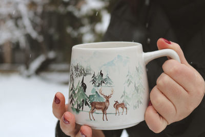 Cropped hand holding coffee cup