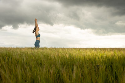 Woman standing on field against sky