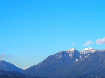 Scenic view of snowcapped mountains against blue sky