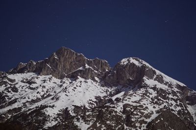 Scenic view of snowcapped mountains against sky at night