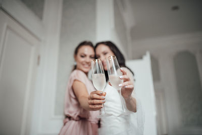 Young woman holding camera while standing on glass