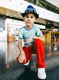 Portrait of boy crouching at mall