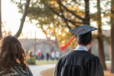 Rear view of students walking in city