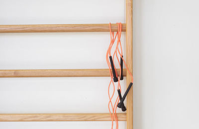 Close-up of jump rope on wood against wall