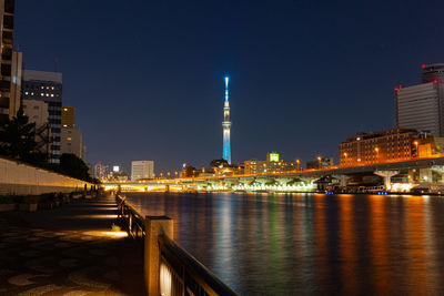 Illuminated buildings at waterfront with skytree 