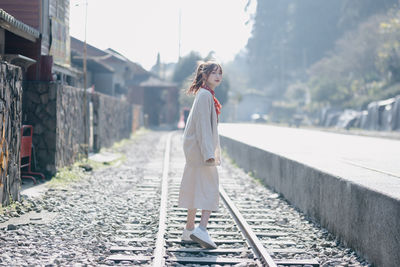 Full length of young woman walking on footpath