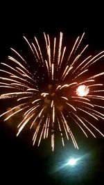 Low angle view of fireworks against sky at night