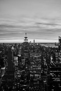 High angle view of city buildings against cloudy sky