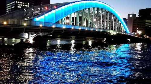 Bridge over river in city at night