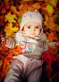 Portrait of cute boy with leaves during autumn