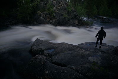 Rear view of man standing on rock