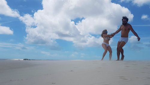 Panoramic view of people on beach against sky