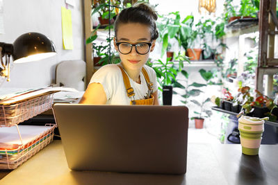 Businesswoman using laptop on table in office