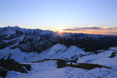 Scenic view of snow mountains against sky during sunset