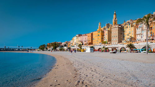 Panoramic view of buildings against clear blue sky