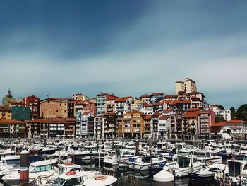 Boats moored in harbor against  old town view