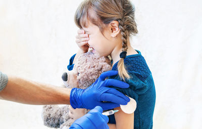 Hands giving vaccination to girl