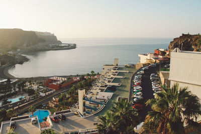 High angle view of town by sea against clear sky
