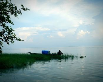 Man on boat in sea against sky