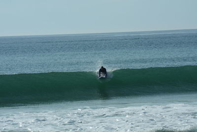 Woman in sea against clear sky