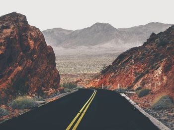 Road amidst mountains against sky