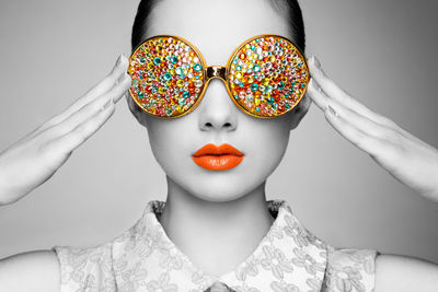 Portrait of woman wearing mask against gray background