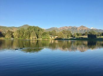 Scenic view of lake against clear blue sky