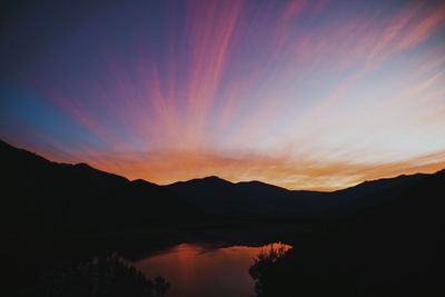 Scenic view of silhouette mountains against romantic sky at sunset