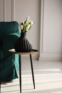 Cropped image of woman sitting on table at home