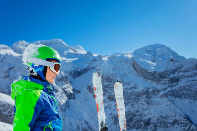 Rear view of man skiing on snowcapped mountain against sky