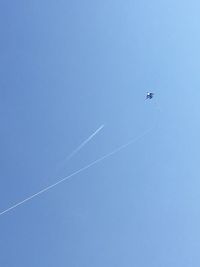 Low angle view of kite flying against clear blue sky