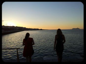 Silhouette of woman looking at sunset