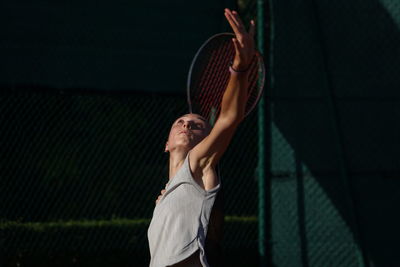 Rear view of woman playing tennis