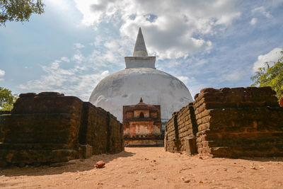 Low angle view of stupa against cloudy sky