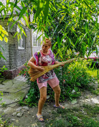 Full length of woman standing against plants