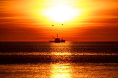 Scenic view of sea against orange sky