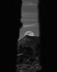 Scenic view of mountain against sky seen through window