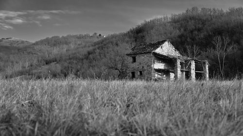 Abandoned barn on field against sky