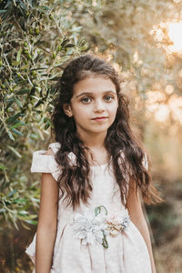 Portrait of teenage girl standing against tree