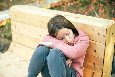 Sad girl sitting on bench