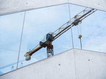 Low angle view of crane against sky