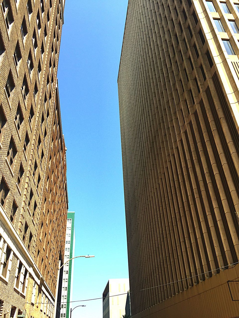 LOW ANGLE VIEW OF MODERN BUILDING AGAINST CLEAR BLUE SKY