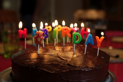 Close-up of illuminated birthday candles on cake