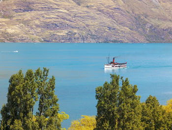 Steamer sailing along lake wakatipu, against the background of the remarkable mountain range