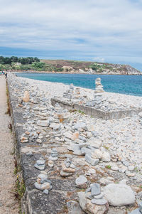 Stones on beach against sky